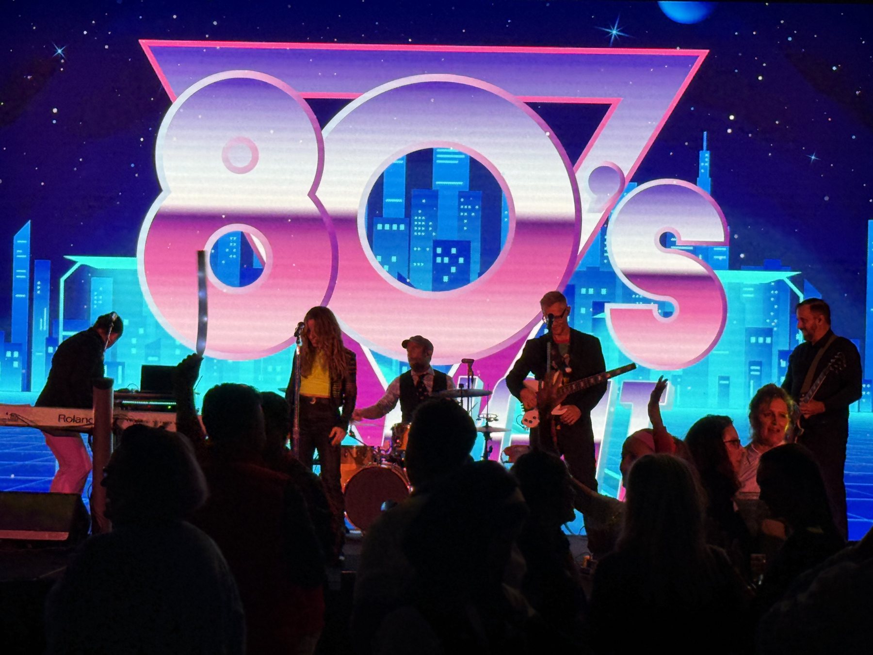 Live band on stage with an 80s themed LED wall, event production by EchoHead Productions